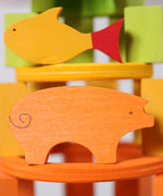 A close up of the Grimms wooden orange pig and yellow fish figure from the counting and story telling set available at Babipur showing the hand painted detail