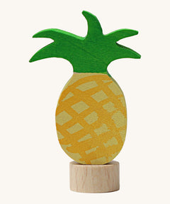 A Grimms pineapple wooden decorative figure with green leaves and a small base stand to slot into a decorative ring