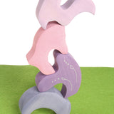 Pieces from the Grimm's casa coral wooden toy stacking puzzle stacked up. Four piece pink and lilac block puzzle.