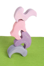 Pieces from the Grimm's casa coral wooden toy stacking puzzle stacked up. Four piece pink and lilac block puzzle.