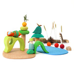 Grimm's wooden Waldorf small world play toy set laid out on a white background with some shells