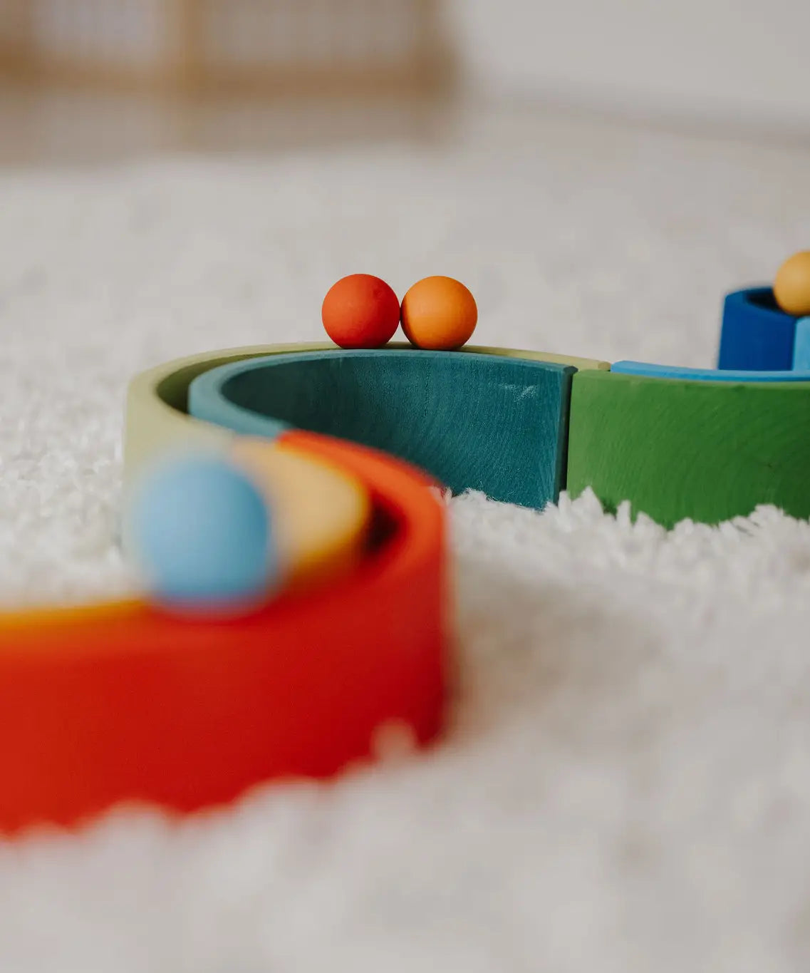 Close up of a Grimms small red and orange ball on a ball run