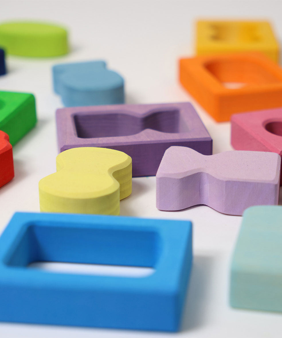 A close up of the window and shape blocks included in the Grimm's Windows Building Set wooden blocks in a wooden storage tray. These Grimm's wooden blocks are part of a wide range of wooden toys available here at Babipur. 