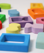 A close up of the window and shape blocks included in the Grimm's Windows Building Set wooden blocks in a wooden storage tray. These Grimm's wooden blocks are part of a wide range of wooden toys available here at Babipur. 