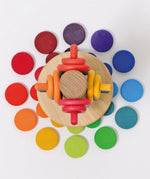 Overhead view of a Grimms wooden sorting helper with rings and coins near the base
