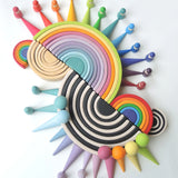 A collection of Grimms 12, medium, and mini piece wooden rainbow piece sets with the forest, balls and peg doll sets