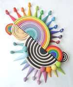 A collection of Grimms 12, medium, and mini piece wooden rainbow piece sets with the forest, balls and peg doll sets