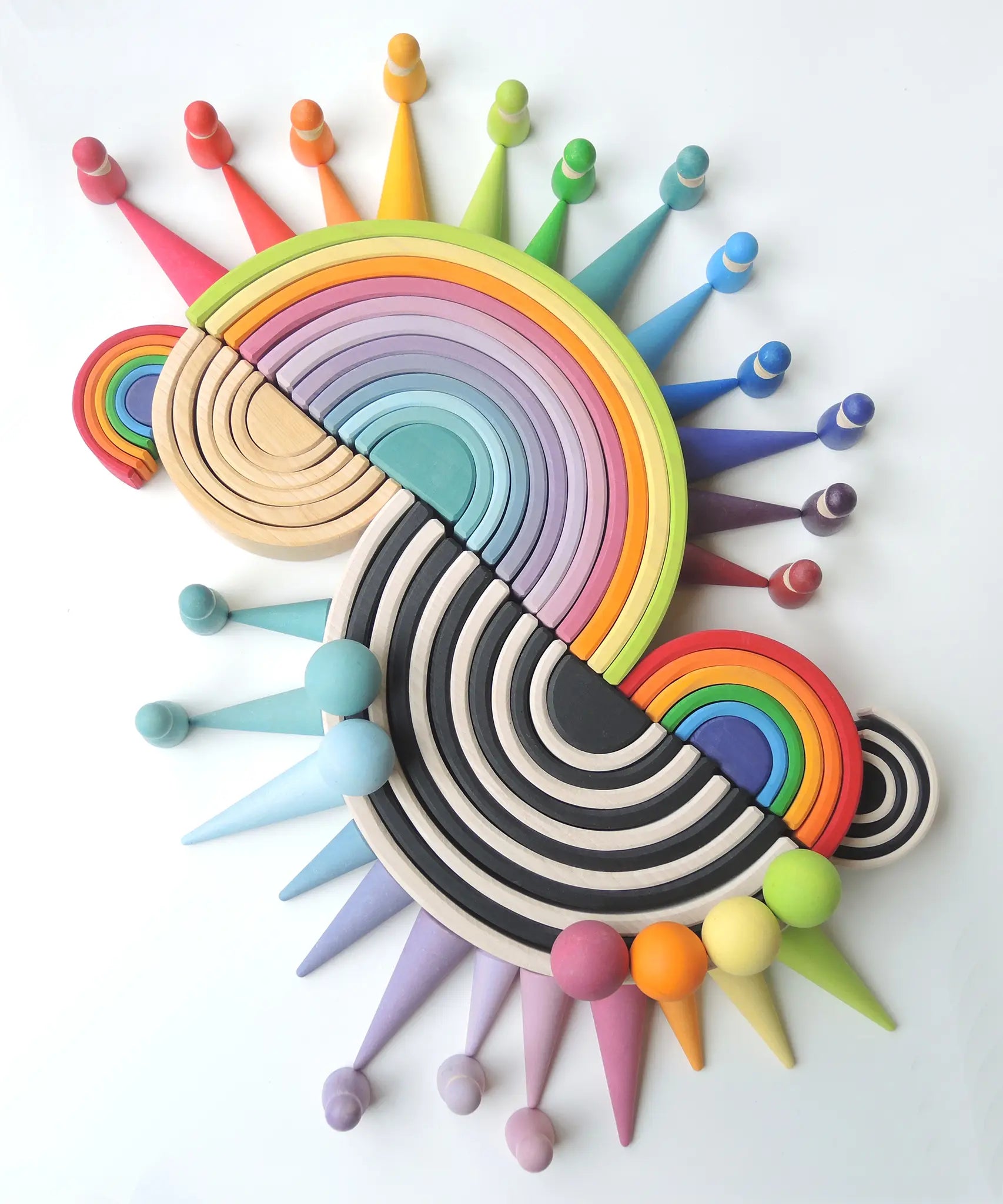 A collection of Grimms 12, medium, and mini piece wooden rainbow piece sets with the forest, balls and peg doll sets