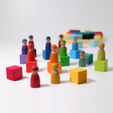 Grimms rainbow wooden cubes with Friends peg dolls on top.