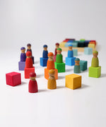 Grimms rainbow wooden cubes with Friends peg dolls on top.