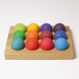 Grimms handcrafted wooden sorting board  showing rainbow coloured balls sitting on the slots