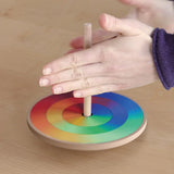 Grimms handcrafted wooden rainbow hand spinning top in action showing a blend of rainbow colours