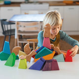 Child playing with the Grimm's rainbow lion wooden building blocks set.