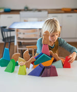 Child playing with the Grimm's rainbow lion wooden building blocks set.