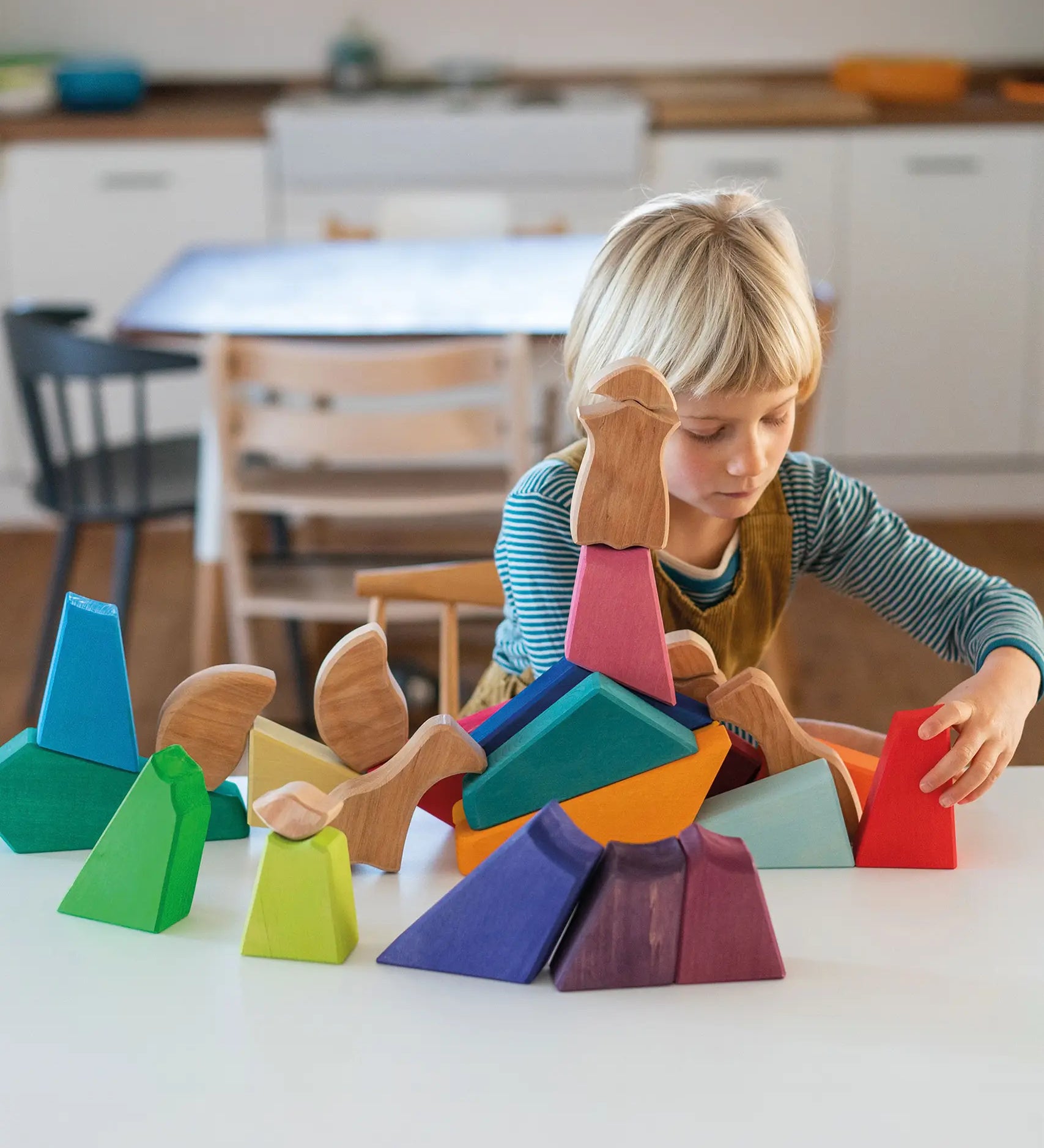 Child playing with the Grimm's rainbow lion wooden building blocks set.