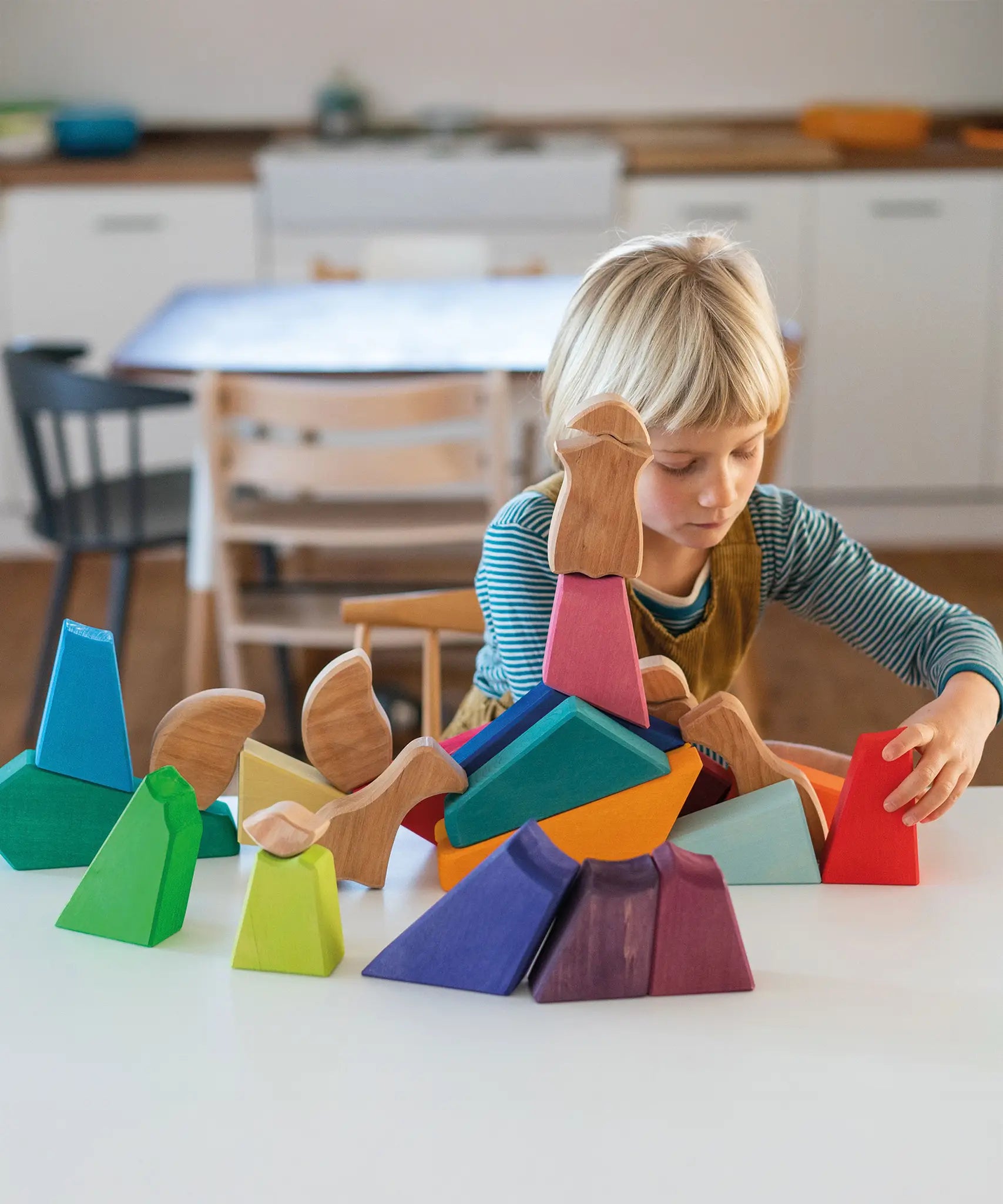 Child playing with the Grimm's rainbow lion wooden building blocks set.