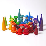 A rainbow coloured display using Grimms wooden loose pieces including balls, peg dolls and rings