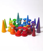A rainbow coloured display using Grimms wooden loose pieces including balls, peg dolls and rings