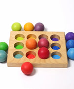 Grimms handcrafted wooden sorting board showing rainbow coloured balls on top