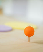 An orange coloured rainbow spinning top in motion. These Grimm's toys are part of a wide range of wooden toys available here at Babipur. 