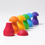 The mushrooms from the Grimm's Rainbow Mushrooms Sorting Game all lined up next to each other.