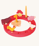 Grimm's Red 12-Hole Celebration Ring with decorative figures on a plain background. 