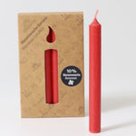 A pack of 12 Red 10% beeswax candles by Grimm's with one red candles placed in front of the box.