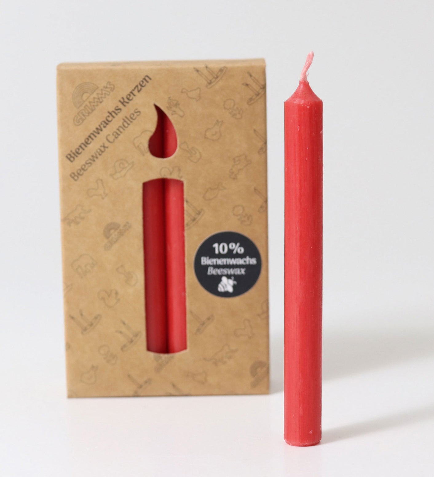 A pack of 12 Red 10% beeswax candles by Grimm's with one red candles placed in front of the box.