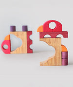 A stack created using pieces from the Grimm's red building set. The stack loosely resembles the shape of a bird. These Grimm's toys are part of a wide range of wooden toys available here at Babipur. 