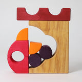 A stack created using pieces from the Grimm's red building set. The stack  resembles the shape of a castle. These Grimm's toys are part of a wide range of wooden toys available here at Babipur. 