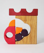 A stack created using pieces from the Grimm's red building set. The stack  resembles the shape of a castle. These Grimm's toys are part of a wide range of wooden toys available here at Babipur. 