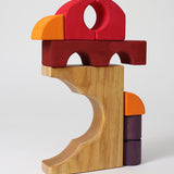 A stack created using pieces from the Grimm's red building set. The stack loosely resembles the shape of a bird. These Grimm's toys are part of a wide range of wooden toys available here at Babipur. 