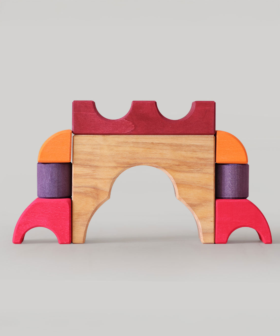 A stack created using pieces from the Grimm's red building set. The stack  resembles the shape of a castle. These Grimm's toys are part of a wide range of wooden toys available here at Babipur. 