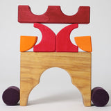 A stack created using pieces from the Grimm's red building set. The stack  resembles the shape of a castle. These Grimm's toys are part of a wide range of wooden toys available here at Babipur. 