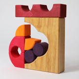 A stack created using pieces from the Grimm's red building set. The stack  resembles the shape of a castle. These Grimm's toys are part of a wide range of wooden toys available here at Babipur. 