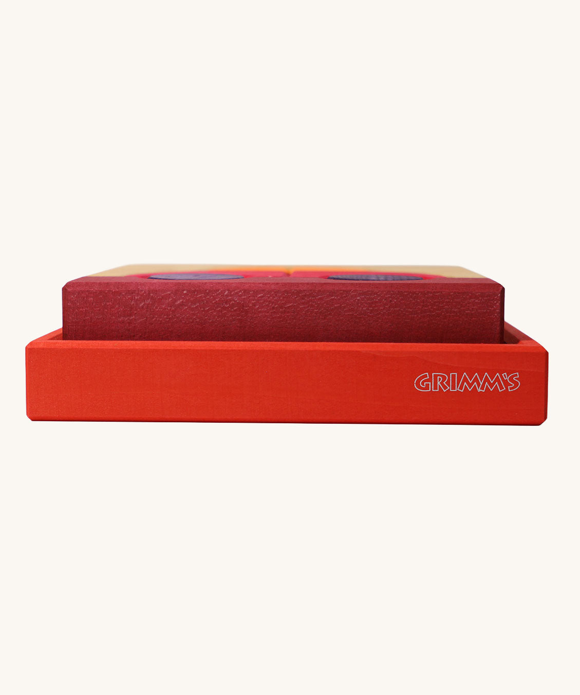 A side profile view of the red coloured wooden tray that the Grimm's red building set comes in. These Grimm's toys are part of a wide range of wooden toys available here at Babipur. 