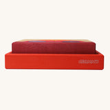 A side profile view of the red coloured wooden tray that the Grimm's red building set comes in. These Grimm's toys are part of a wide range of wooden toys available here at Babipur. 
