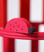 A close up of the Grimms wooden red ladybird figure from the counting and story telling set available at Babipur showing the hand painted detail