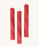 A set of 3 Grimms red marbled candles made from beeswax