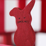A close up of the Grimms wooden red rabbit figure from the counting and story telling set available at Babipur showing the hand painted detail