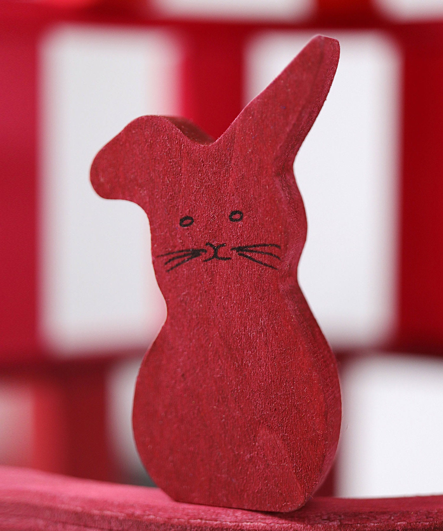 A close up of the Grimms wooden red rabbit figure from the counting and story telling set available at Babipur showing the hand painted detail