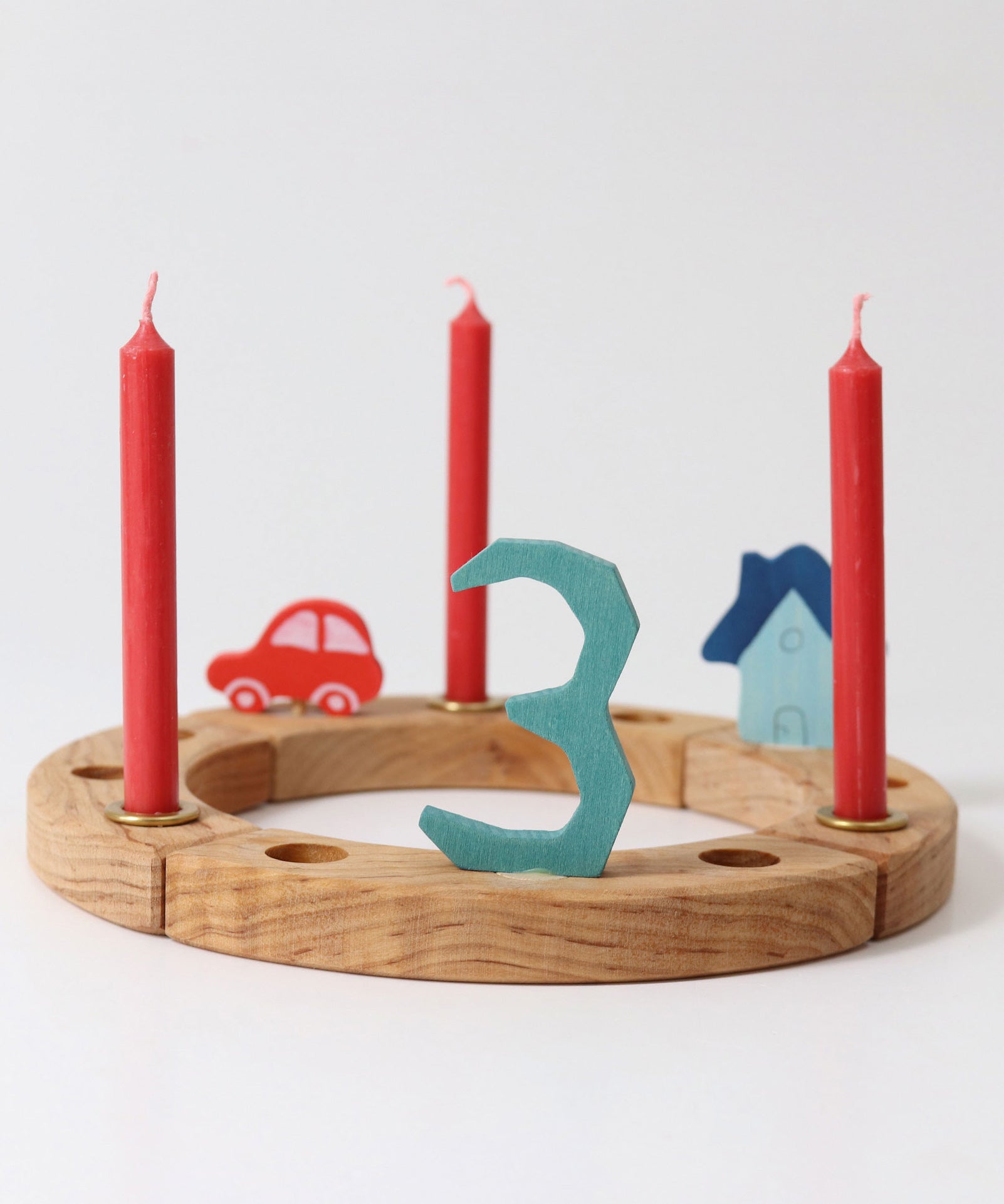 Grimm's Red 10% beeswax candles placed on a natural celebration ring. 