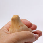 A close up of the Grimm's wooden relaxing bird toy being held in an adult's hand.