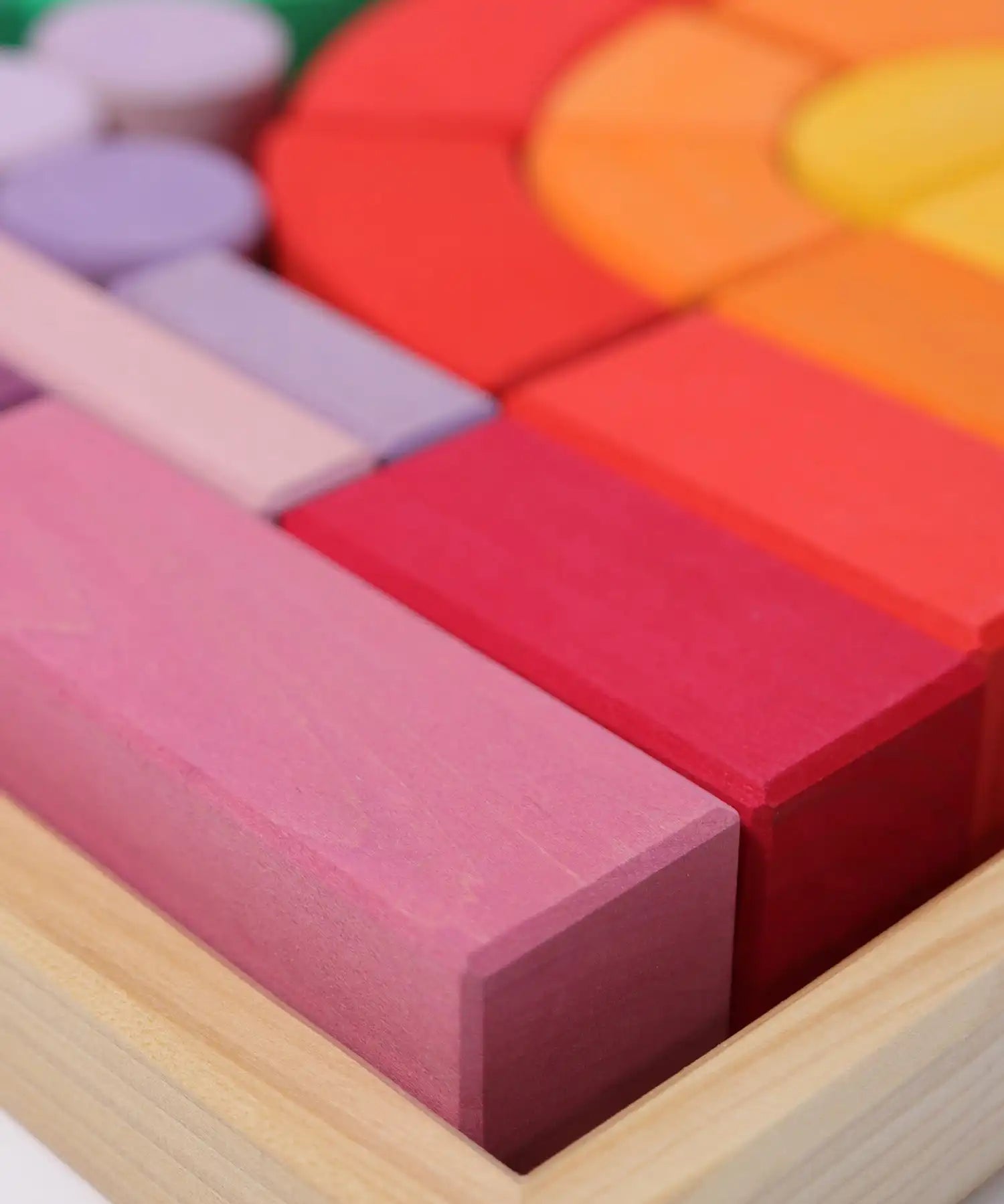 Close up of the Grimm's large Romanesque building set blocks in the wooden storage display tray. 