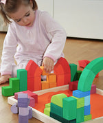 Child playing with the Grimm's large Romanesque building set.