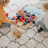 Children playing with the Grimms large stepped wooden counting blocks in Grimm’s World of Numbers palette 