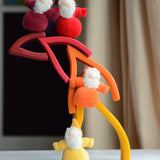 Flame shaped pieces from the Grimms fire set stacked with dwarf dolls standing on top