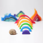 Pieces from the Grimm's Small 4 Elements Building Set taken out of the wooden storage and display case. The pieces of the rainbow element can be seen in the front.
