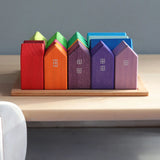 Grimm's small rainbow wooden houses set. 15 different colour houses in various sizes on a wooden plinth tray.