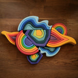Grimms wooden mini and large elements set including water, earth, fire an a rainbow laid flat on a table